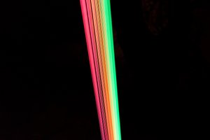 A photo of the artwork Spectral. Many strands of brightly neon coloured cord all run in the same direction, closely spaced.