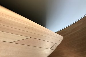 A detail of a curved wooden wall receding in to the distance.