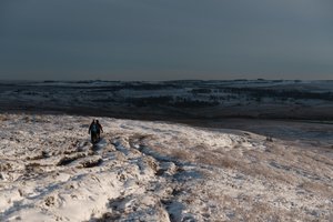 A pair of walkers decend a snow covered hill.