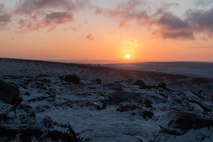 Sunrise over lightly snow covered hills.
