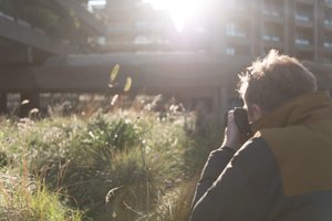 A photo of James Greig as he takes a photo of some shrubs silhouette against the sun.
