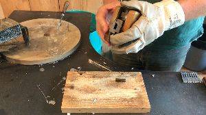 A craftsman pours molten lead in to a mold to produce a piece of movable type.