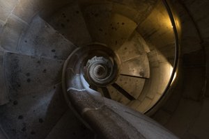 Looking directly down a tight stone spiral staircase