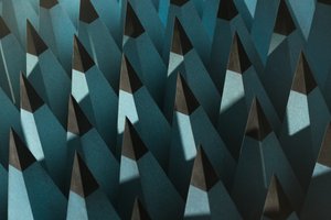 A close photo of some radio-wave insulating foam. The foam is formed in to tall pointy pyramids with pale blue bases and black tips. The pyramids are arranged in a rigid grid - as if the entire floor were spikey.
