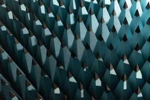 A photo of some radio-wave insulating foam. The foam is formed in to tall pointy pyramids with pale blue bases and black tips. The pyramids are arranged in a rigid grid - as if the entire floor were spikey.