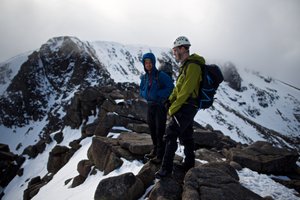Chris and our instructor stand on a level section of Fiacaill ridge. There’s low cloud on the mountain, but some sunlight just breaking through.