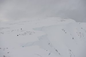 Ed in far distance is a dark spec on an otherwise white mountain.