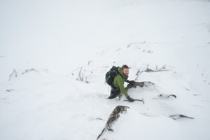 Ed looks back to the camera as he descends a steep snowy ridge.