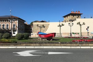 Looking across to the other side of a street in Getaria. In the central divider there is a red rowing boat.
