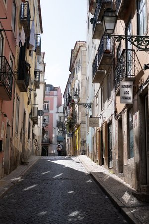 Looking up a narrow street in bright sunlight.