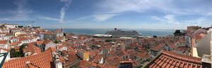 A panorama of the neighbourhood of Alfama from a viewpoint. There’s a large cruise ship in the see directly in front.