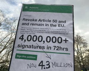 A large protest sign high in the air. The sign shows the Article 50 petition on petition.parliament.uk and in large letters shows that it had more than 4.3 million signatures.