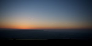 Twilight over the South Downs. The sky is clear with yellow and orange hues on the horizon.