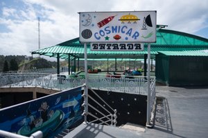 A retro looking sign that reads ‘Cosmicar entrada’ with sci-fi looking graphics.