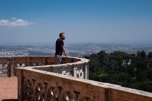A photo of Ed Horsford looking out over a round balcony to the landscape of Sintra beyond