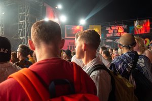 Oj and Rogan wait in a crowd for a band to start.