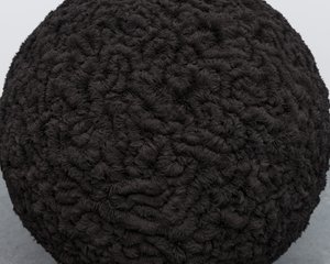 A large black sphere in the corner of a white room. The sphere has a complex detailed texture. The texture is made from iron filings attracted to the sphere.