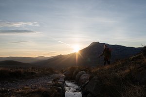 Ed walking towards the camera, approaching a small stream. It’s just after dawn and the sun is directly in front.