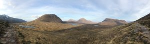 Panorama from side of Beinn Eighe. The landscape is brown with patches of green in a partially sunny day.