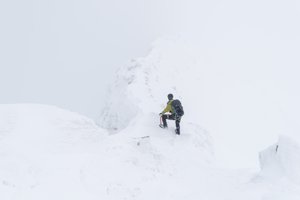 Chris at the start of the CMD Arete, going down. It’s very snowy with low visibility. The ridge is only just visible.