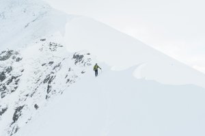 Chris walking along the Devil’s ridge towards the camera. He’s on one side of a sharp snowy ridge.