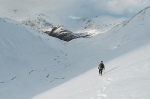 Chris descending in to the bowl of the Ring of Steall. It’s later in the day and the sun is low in the sky. The bowl is already in shadow. There’s a small windy stream at the base of the bowl.
