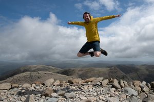 Ed jumping in the air on the summit of Scafell Pike.