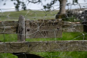 An aged wooden sign on a fence says ‘No right of way’ - it’s also covered in chicken wire.