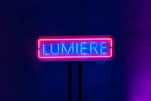 A neon sign with the word ‘Lumier’ in blue, surrounded by red neon.
