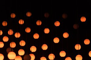 Orange balls of light hand suspended from darkness