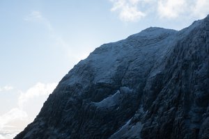 The summit of snowdon seen from just below. The summit is in shadow with a light dusting of snow.