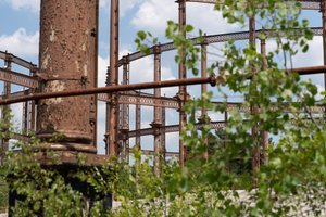 A tight crop through brambles of various parts of gas works railing.