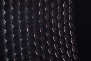 A close crop of what looks like a large multi-faceted glass lens or many small mirrors.