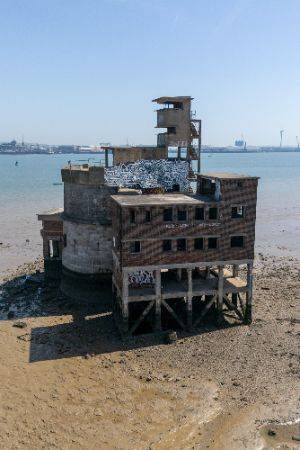 Portrait photo of the exterior of one side of the battery showing a rectangular structure on stilts.
