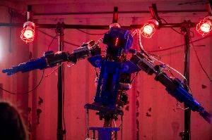 A robot with arms, surrounded by red lights.