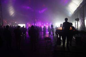 DJ booth and people dancing in a dark tent