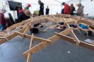 A bunch of wooden slats connected together to form a dome about 4m across.