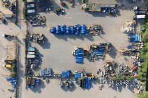 Drone photo facing straight down, looking at an industrial storage yard filled with plastic pipes.