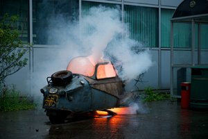 A Messerschmitt car on fire after being blown up.