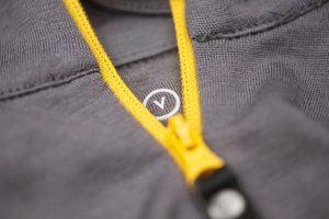Detail photo of the zipper of a grey jersey.